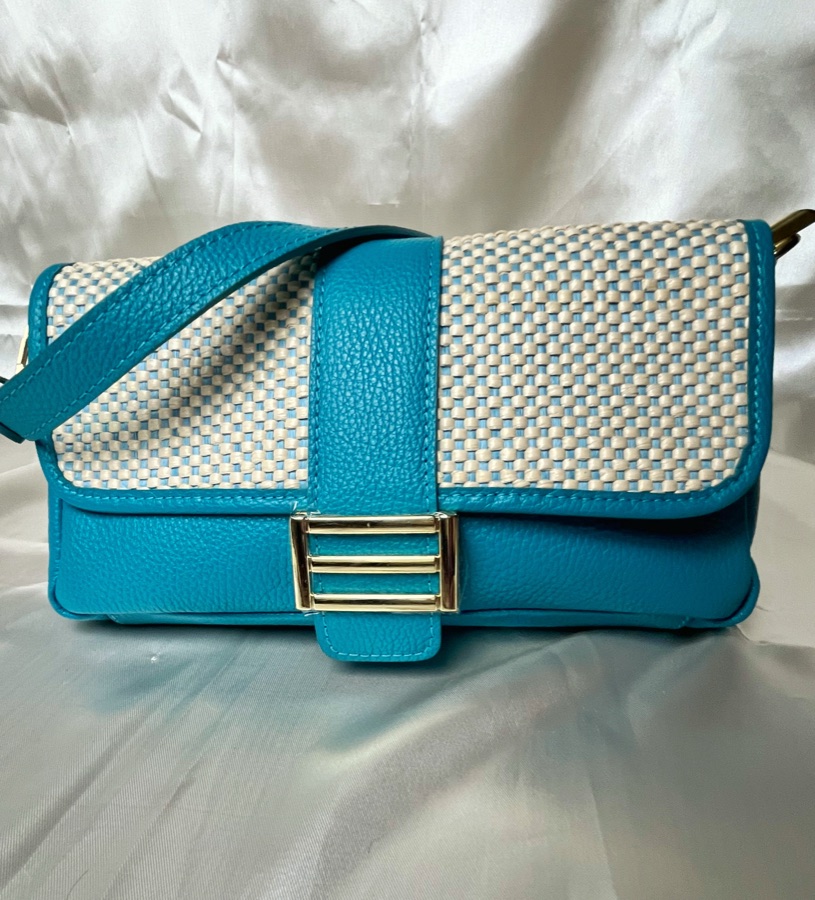 Flat lay of a teal and woven leather handbag