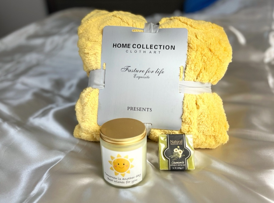 Flat lay of a home collection towel set, candle and soap